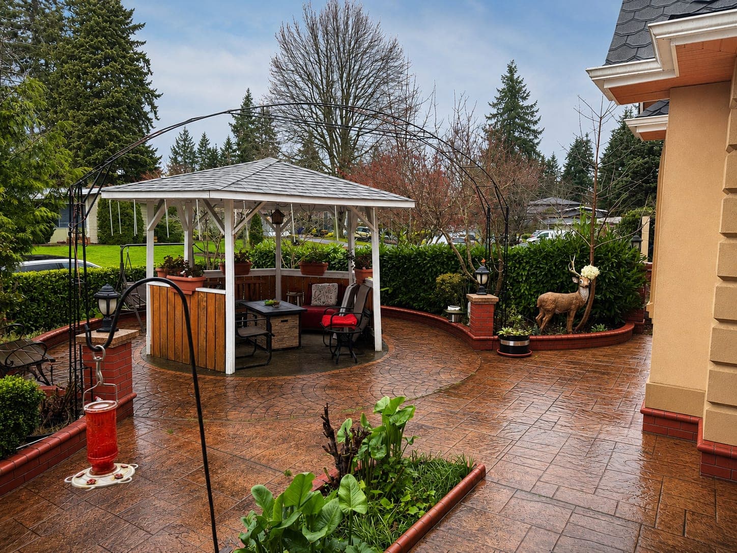 The back garden, with a covered seating area looking out over the lawn and trees.