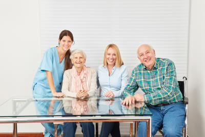 caregiver and happy family in a retirement home