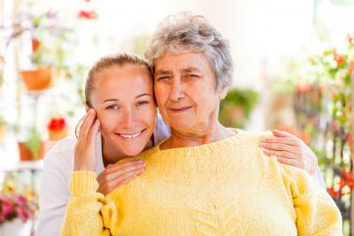 senior woman and caregiver in a flower garden